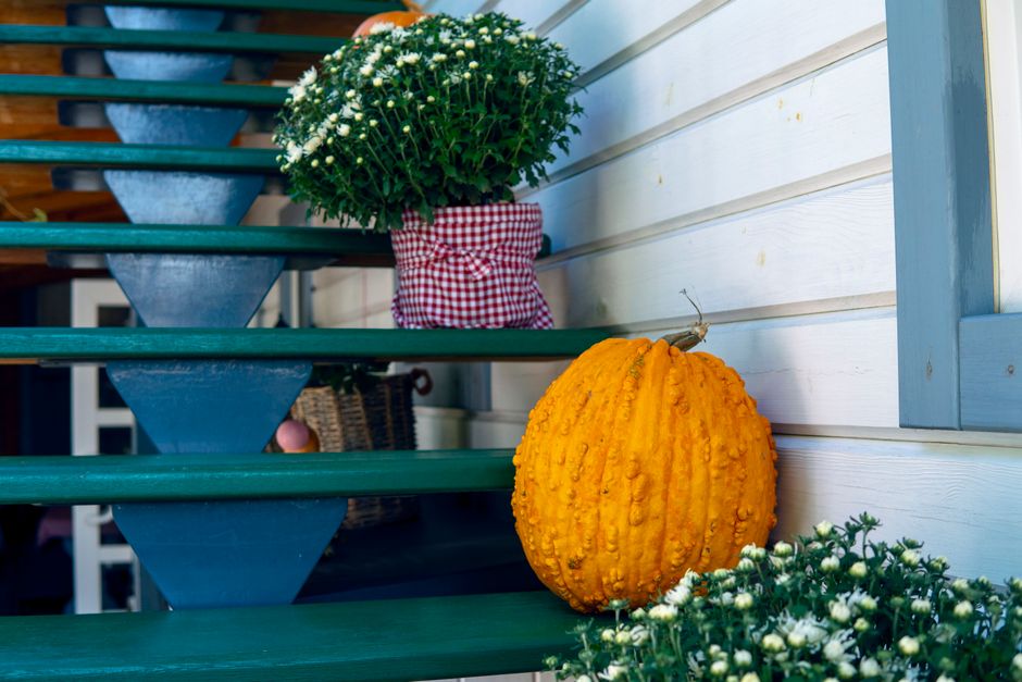 Warme herfstkleuren op veranda met lantaarns.